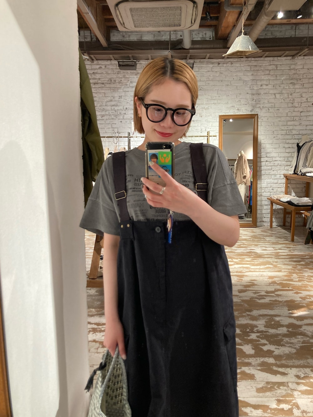 ベージュ系のスニーカー、ブラック系のスカート、グレー系のTシャツ/カットソーを着用したレディースの春コーディネートの5枚目の写真