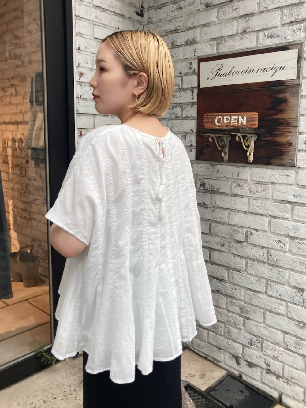 ホワイト系のシャツ/ブラウス、ブラック系のスカート、ブラック系のサンダルを着用したレディースの夏コーディネートの5枚目の写真