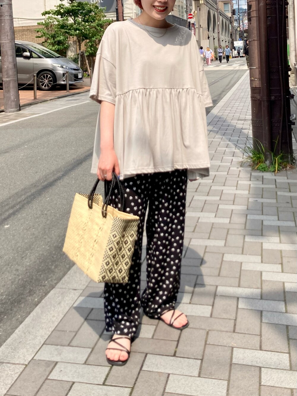 グレー系のTシャツ/カットソー、ブラック系のその他パンツ、ベージュ系のショルダーバッグを着用したレディースの夏コーディネートの2枚目の写真