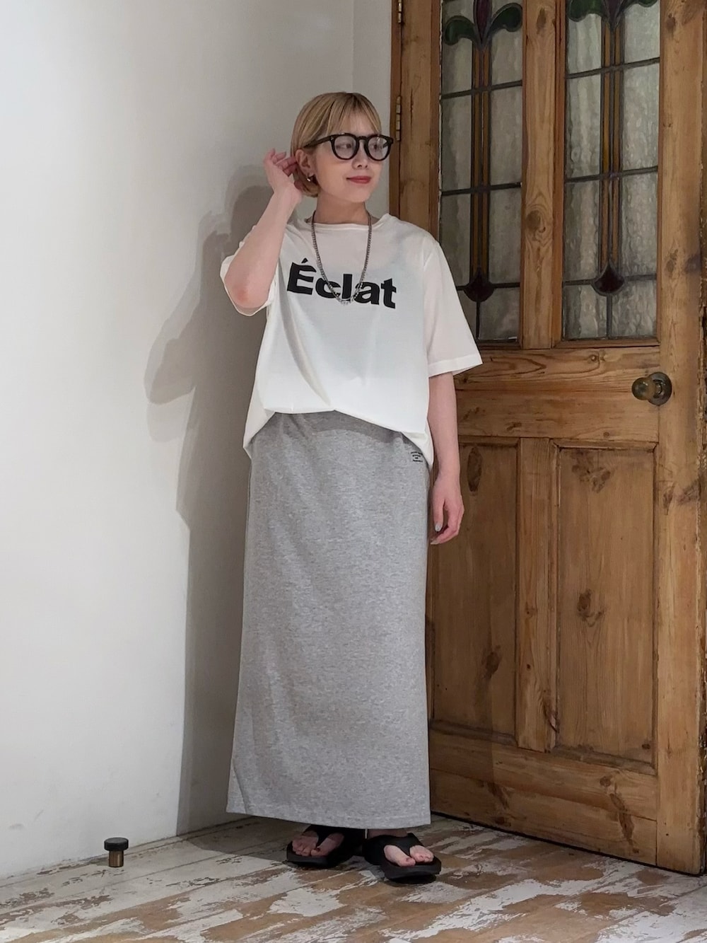 グレー系のスカート、ホワイト系のTシャツ/カットソーを着用したレディースの夏コーディネートの2枚目の写真