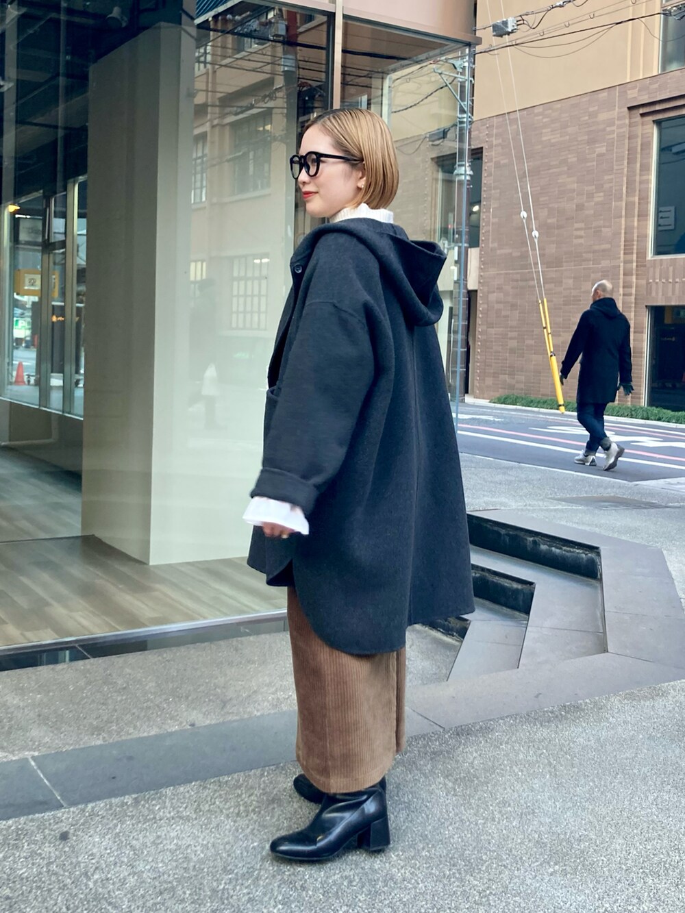 ブラック系のブーツ、ゴールド系のショルダーバッグ、ブラウン系のスカートを着用したレディースの冬コーディネートの2枚目の写真