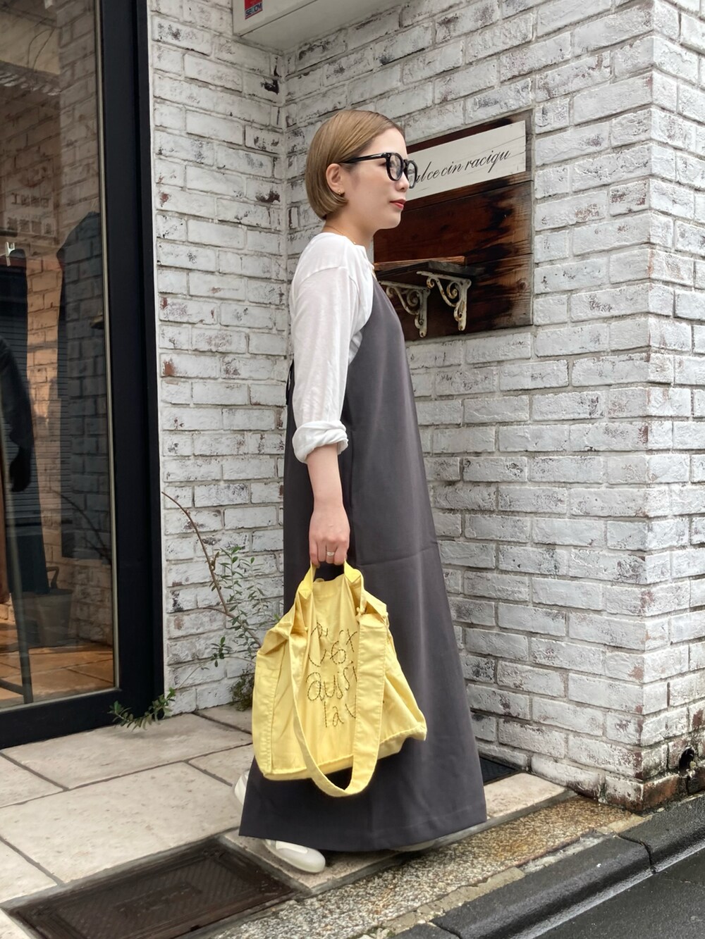ベージュ系のスニーカー、イエロー系のトートバッグ、グレー系のワンピースを着用したレディースの秋コーディネートの2枚目の写真