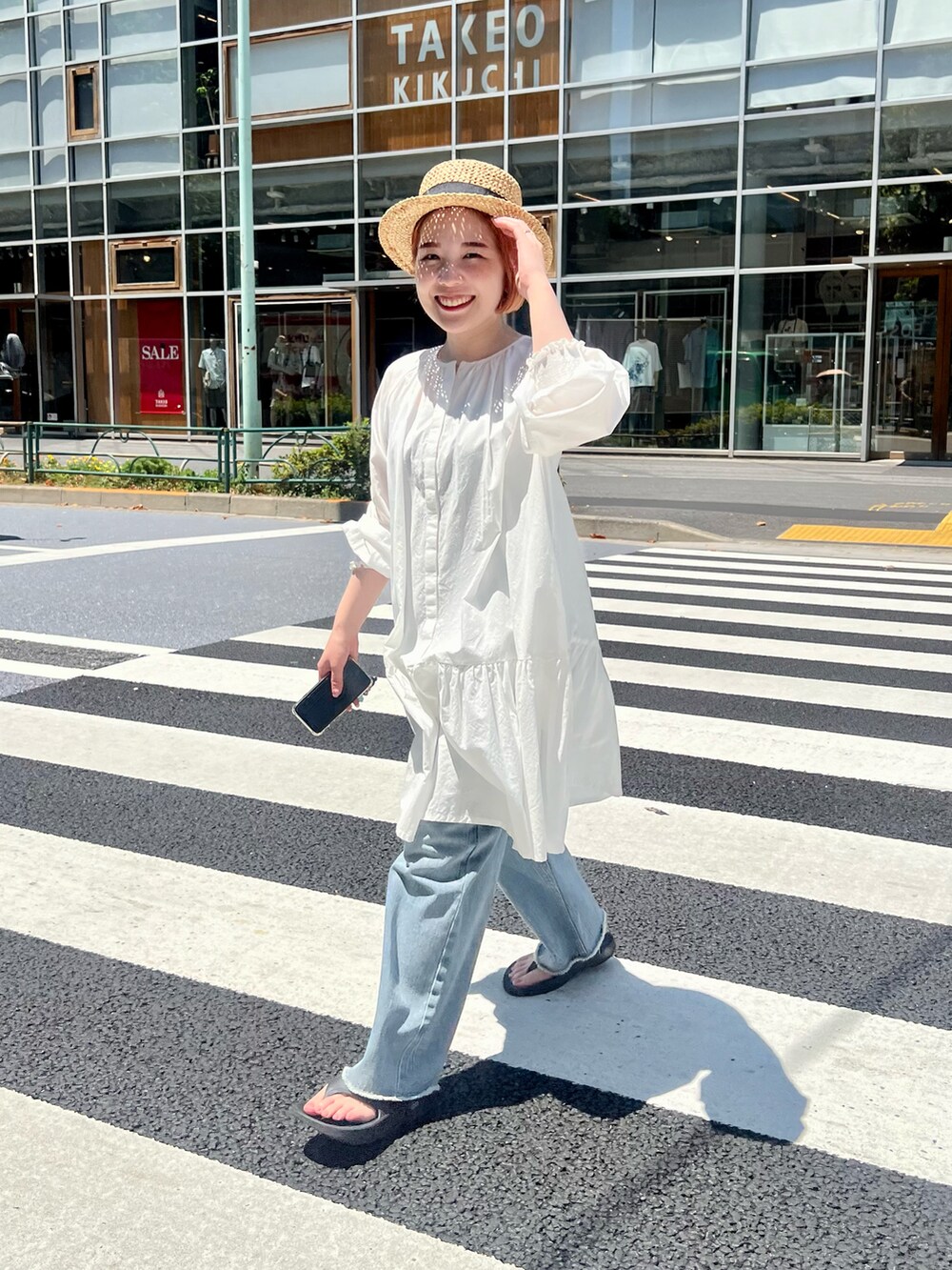 ブラック系のサンダル、ホワイト系のシャツ/ブラウス、ブルー系のデニムパンツを着用したレディースの夏コーディネートの4枚目の写真