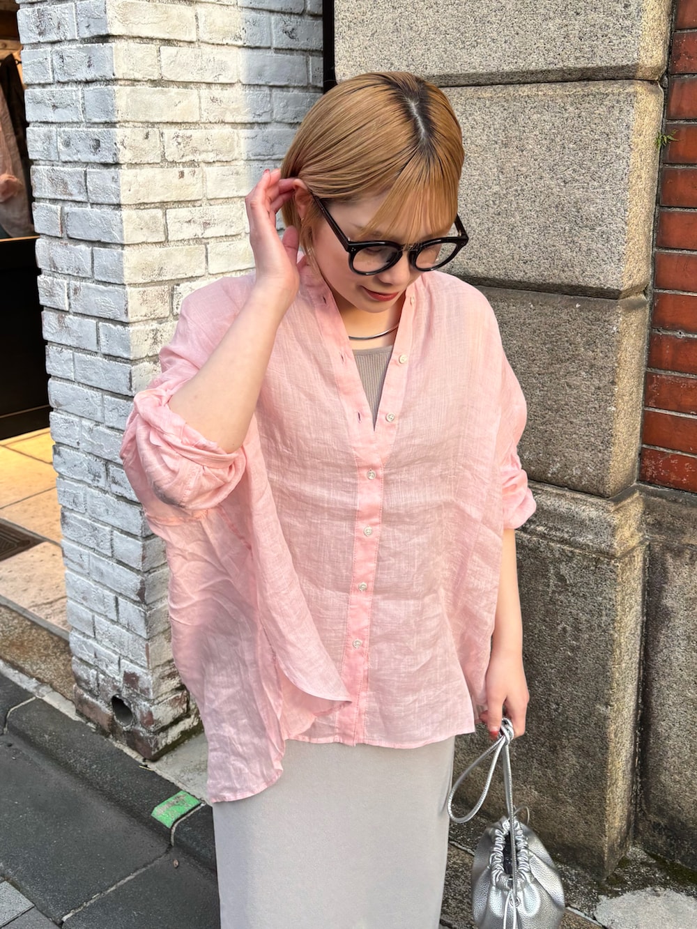 ピンク系のシャツ/ブラウス、グレー系のスカート、シルバー系のショルダーバッグを着用したレディースの春コーディネートの4枚目の写真
