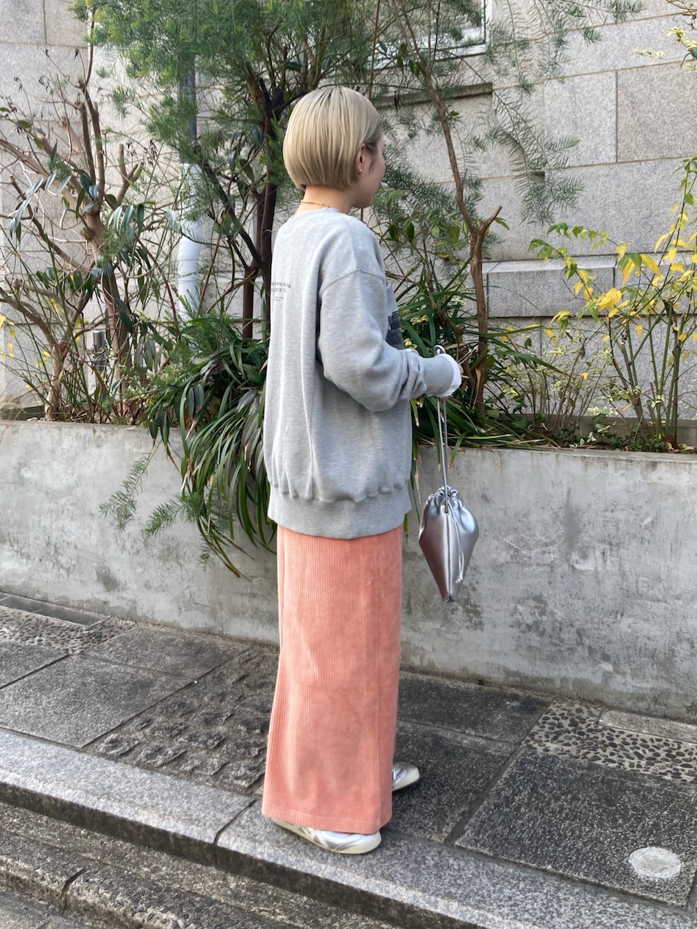 ピンク系のスカート、グレー系のスウェット、ホワイト系のTシャツ/カットソーを着用したレディースの冬コーディネートの3枚目の写真