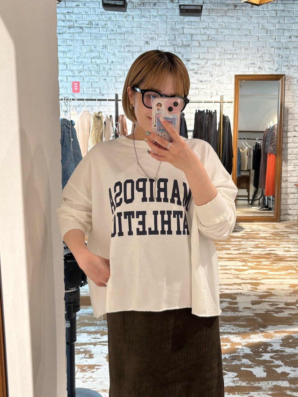 グリーン系のスカート、ホワイト系のTシャツ/カットソー、シルバー系のスニーカーを着用したレディースの夏コーディネートの2枚目の写真