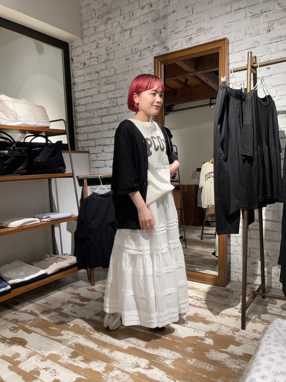 ブラック系のカーディガン/ボレロ、ホワイト系のTシャツ/カットソー、ホワイト系のスカートを着用したレディースの春コーディネートの2枚目の写真