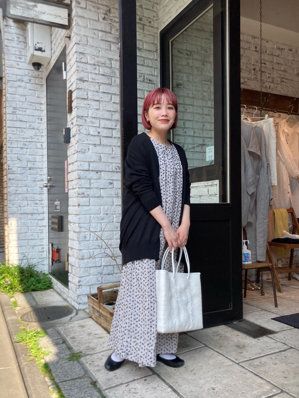 ブラック系のカーディガン/ボレロ、ベージュ系のワンピースを着用したレディースの春コーディネートの3枚目の写真