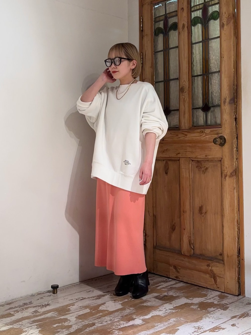 ピンク系のスカート、ホワイト系のスウェットを着用したレディースの春コーディネートの2枚目の写真