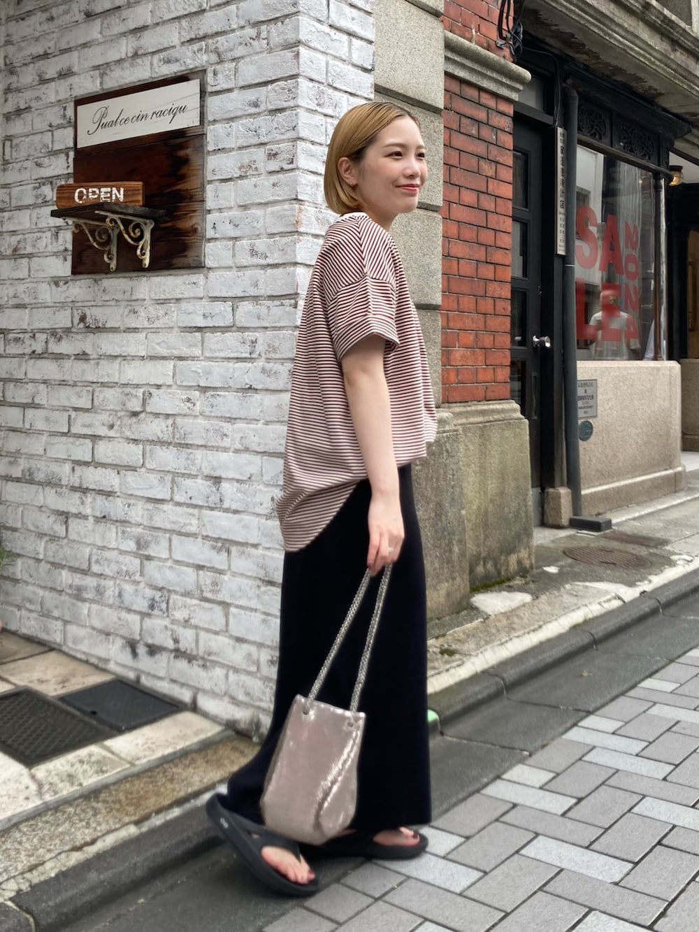 ブラック系のサンダル、ブラック系のスカート、ブラウン系のTシャツ/カットソーを着用したレディースの夏コーディネートの2枚目の写真