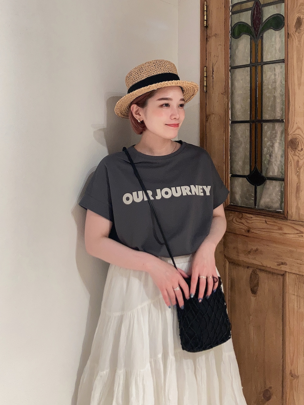 グレー系のTシャツ/カットソー、ホワイト系のスカート、ブラック系のサンダルを着用したレディースの夏コーディネートの5枚目の写真