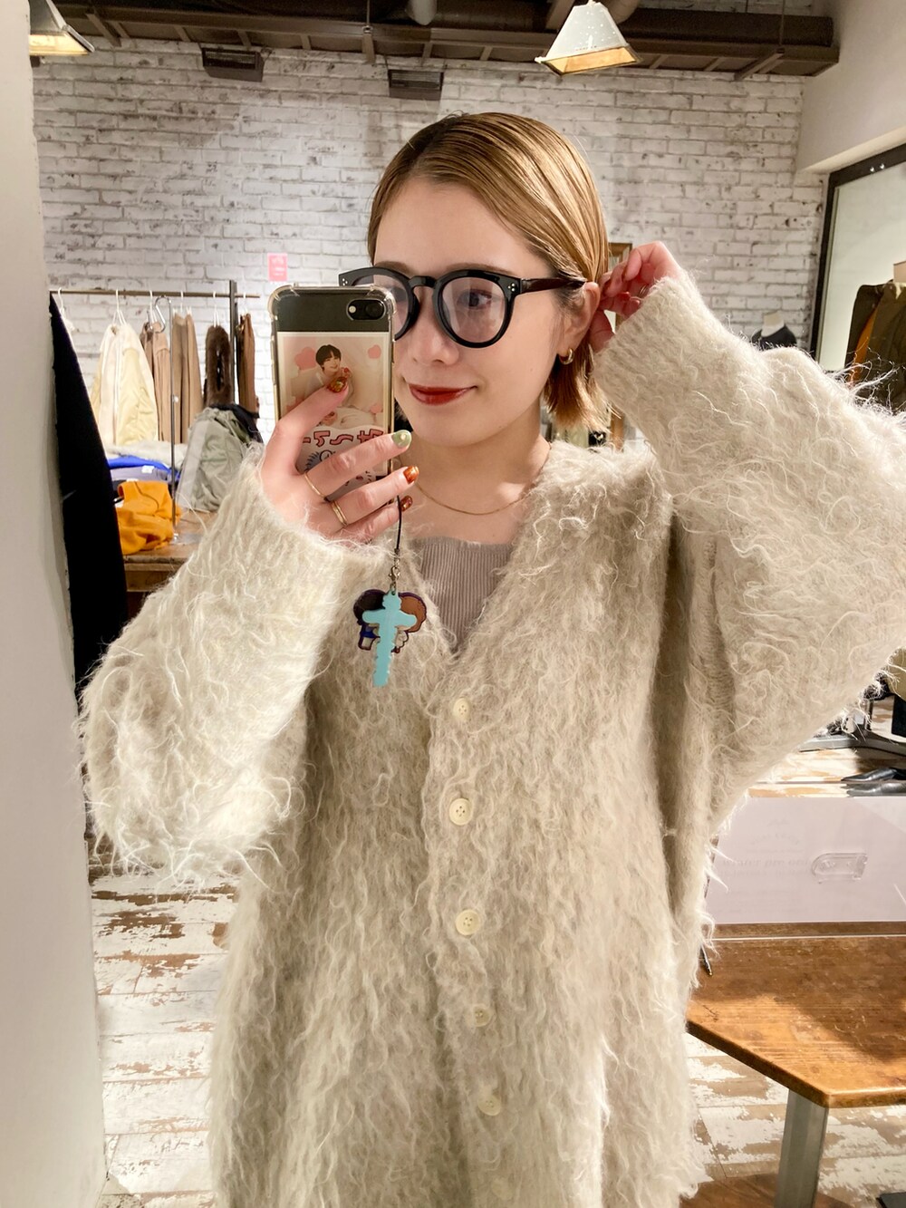 ベージュ系のカーディガン/ボレロを着用したレディースの秋コーディネートの2枚目の写真