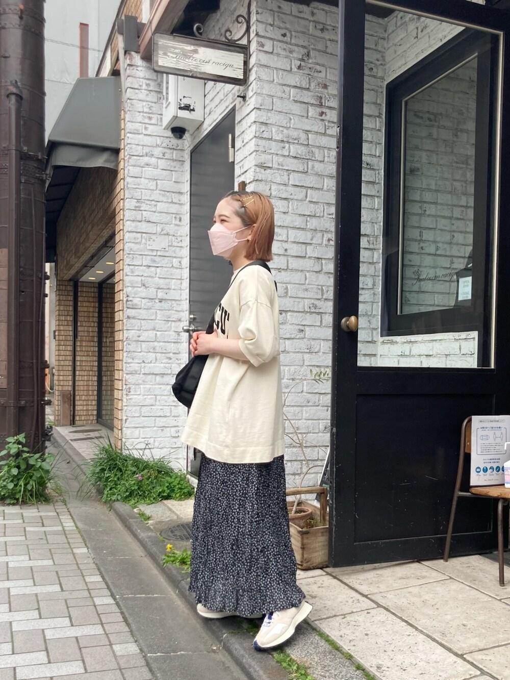 ホワイト系のTシャツ/カットソー、ブラック系のショルダーバッグ、ブラック系のスカートを着用したレディースの春コーディネートの3枚目の写真