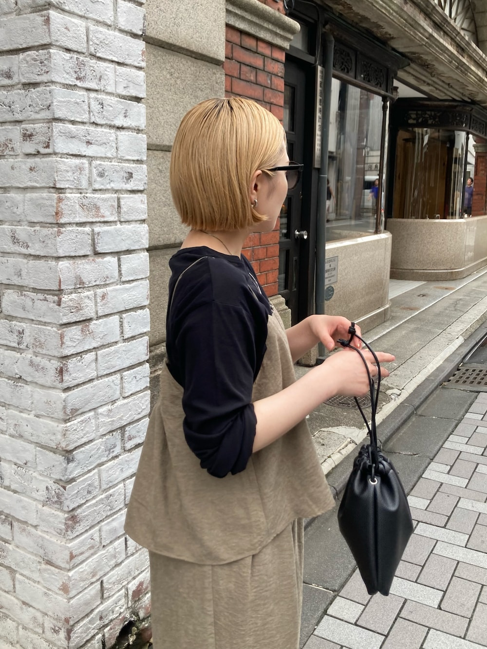 グレー系のスニーカー、ブラック系のショルダーバッグ、ブラウン系のつなぎ/オールインワンを着用したレディースの秋コーディネートの5枚目の写真