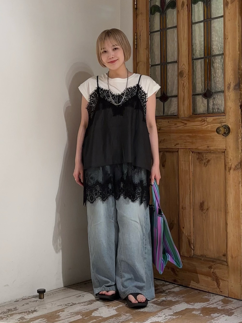 ブルー系のデニムパンツ、ブラック系のキャミソール、ホワイト系のTシャツ/カットソーを着用したレディースの夏コーディネートの3枚目の写真