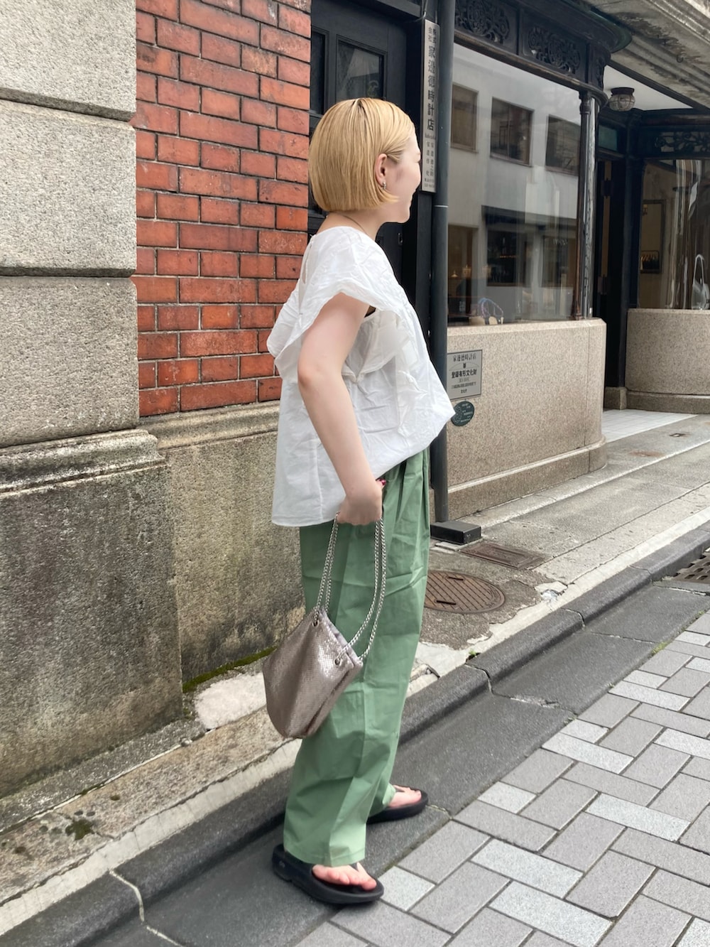 グリーン系のその他パンツ、ホワイト系のシャツ/ブラウス、ブラック系のサンダルを着用したレディースの夏コーディネートの2枚目の写真