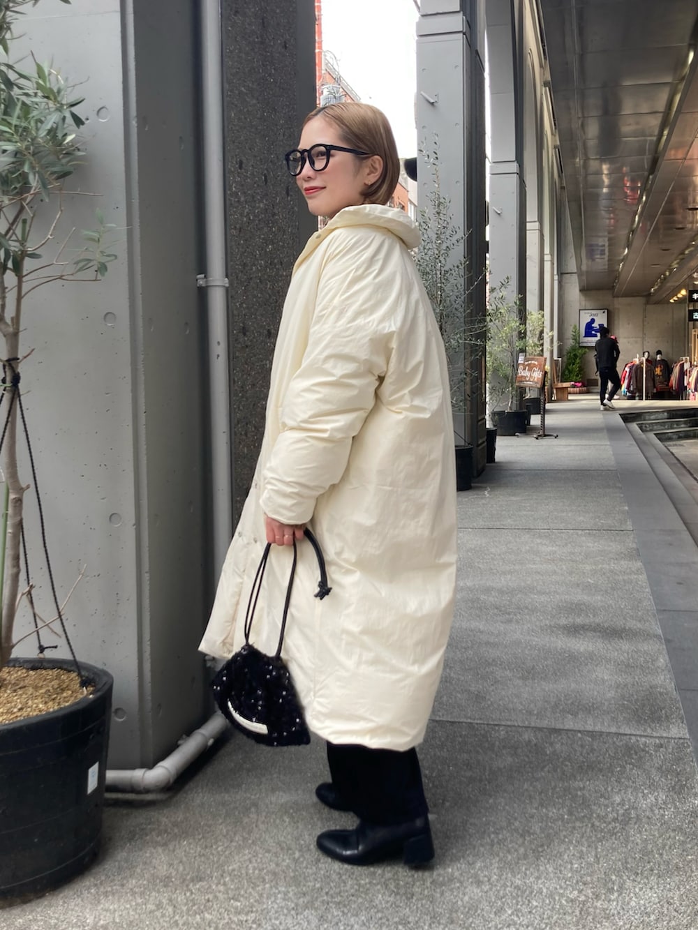 ベージュ系のニット/セーター、ホワイト系のダウンジャケット/コート、ブラック系のスカートを着用したレディースの冬コーディネートの3枚目の写真