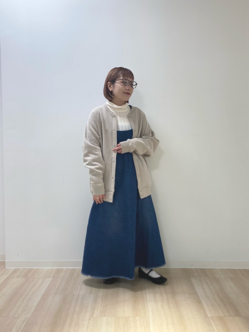 ベージュ系のブルゾン、ブルー系のワンピース、ホワイト系のTシャツ/カットソーを着用したレディースの冬コーディネートの2枚目の写真