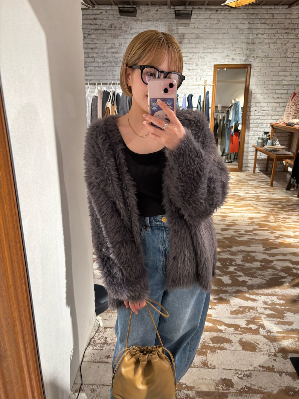 ブルー系のデニムパンツ、グレー系のカーディガン/ボレロ、ブラウン系のショルダーバッグを着用したレディースの秋コーディネートの5枚目の写真