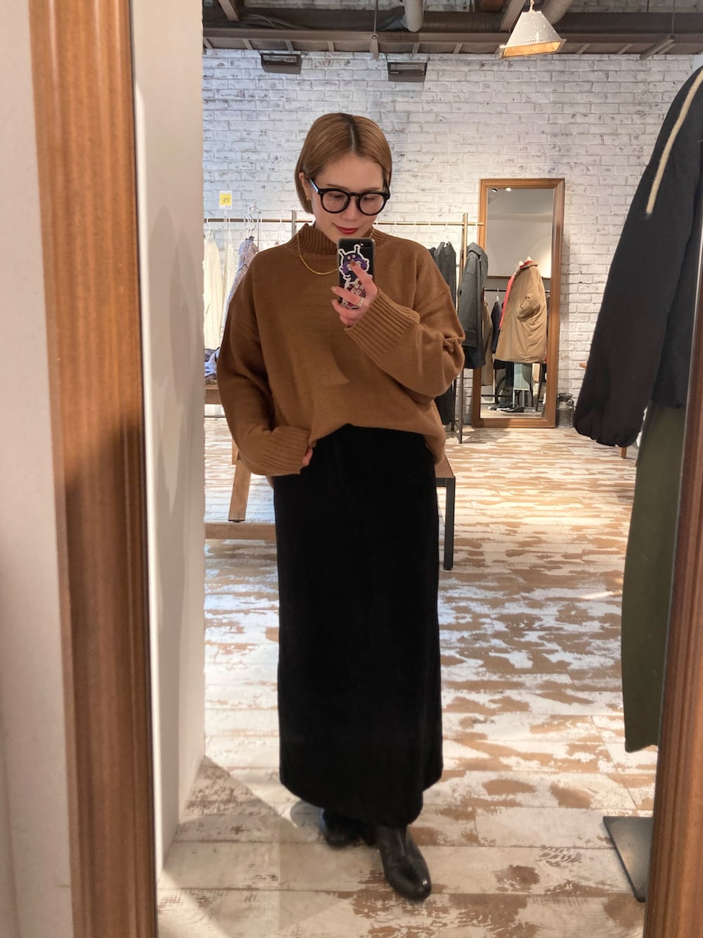 ブラック系のスカート、ベージュ系のニット/セーター、ブラック系のショルダーバッグを着用したレディースの冬コーディネートの3枚目の写真