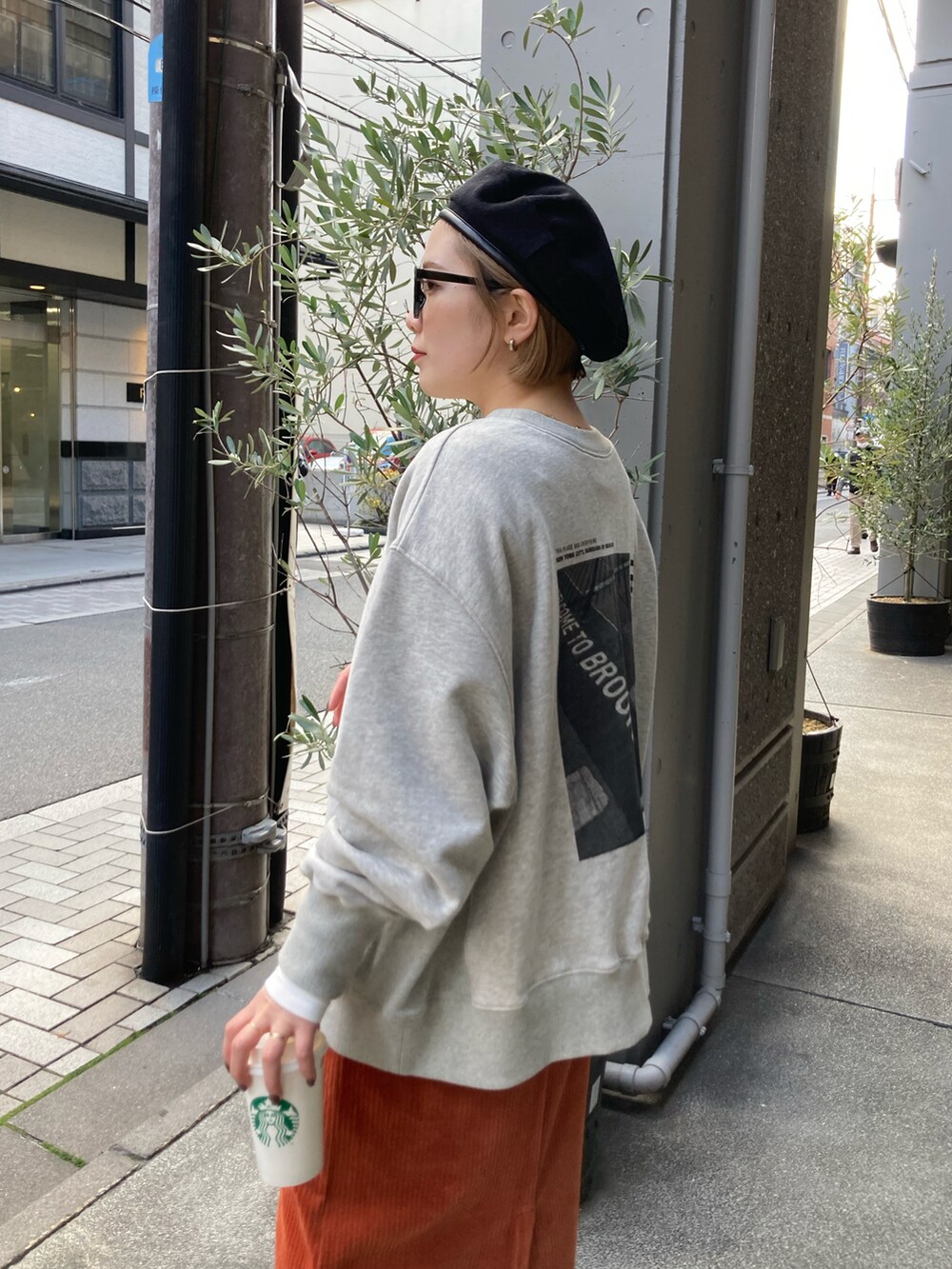 ブラック系のブーツ、オレンジ系のスカート、オレンジ系のスカートを着用したレディースの冬コーディネートの4枚目の写真