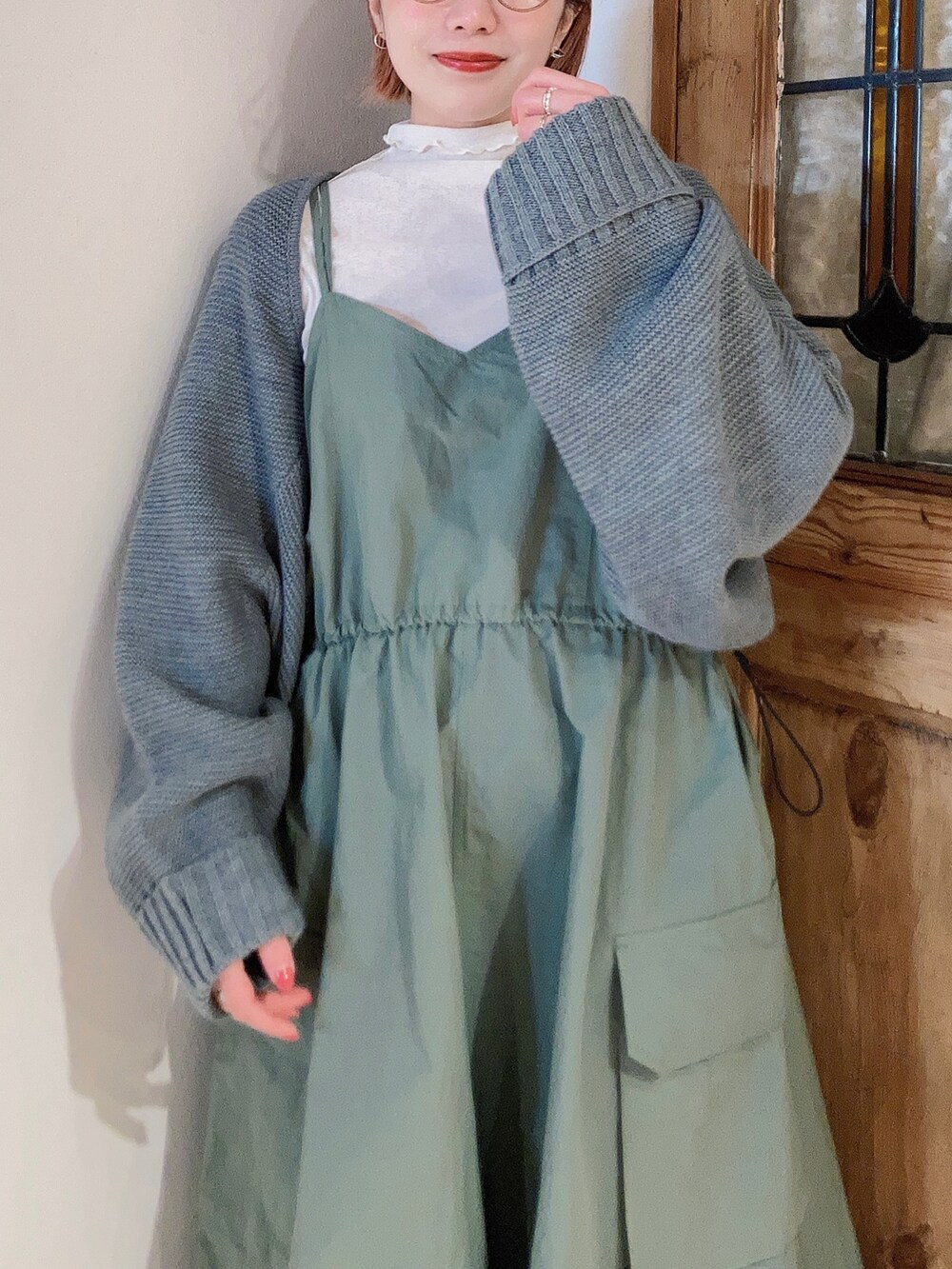 グリーン系のワンピース、ホワイト系のTシャツ/カットソー、グレー系のカーディガン/ボレロを着用したレディースの春コーディネートの4枚目の写真