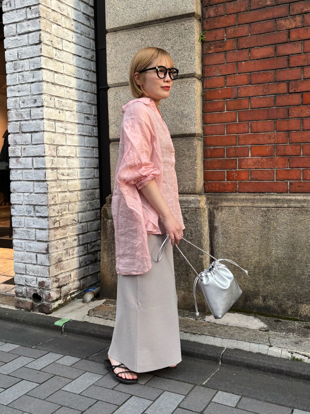 ピンク系のシャツ/ブラウス、グレー系のスカート、シルバー系のショルダーバッグを着用したレディースの春コーディネートの3枚目の写真