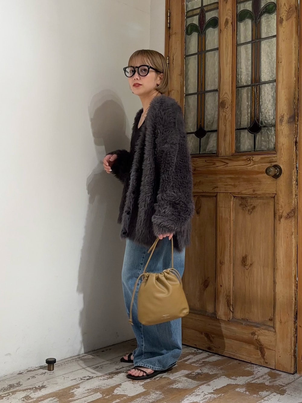 ブルー系のデニムパンツ、グレー系のカーディガン/ボレロ、ブラウン系のショルダーバッグを着用したレディースの秋コーディネートの4枚目の写真