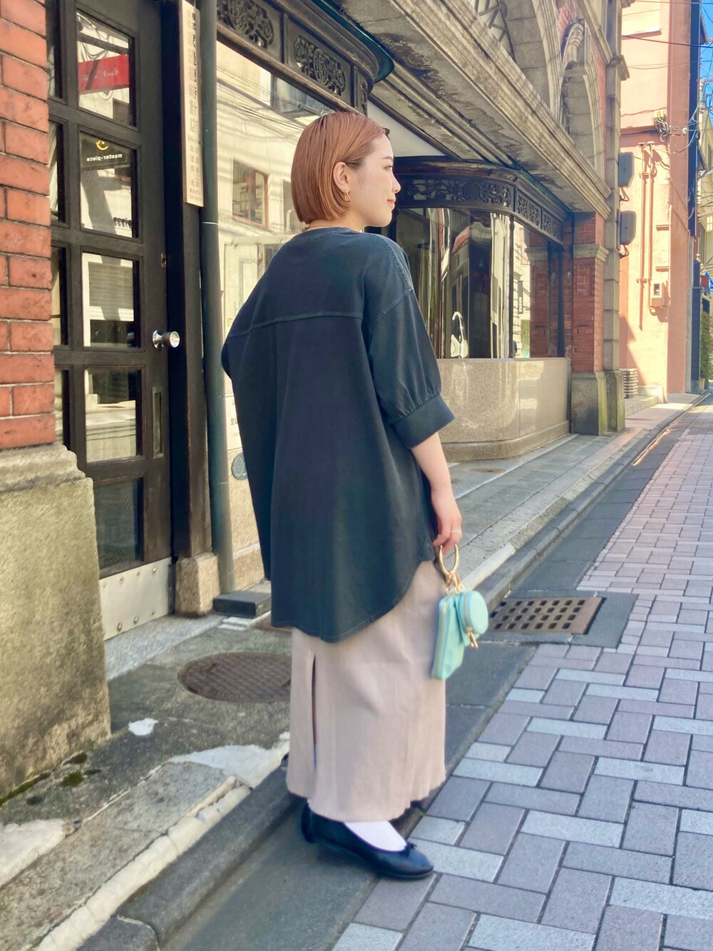 ベージュ系のスカート、ブルー系のショルダーバッグ、グレー系のTシャツ/カットソーを着用したレディースの夏コーディネートの3枚目の写真