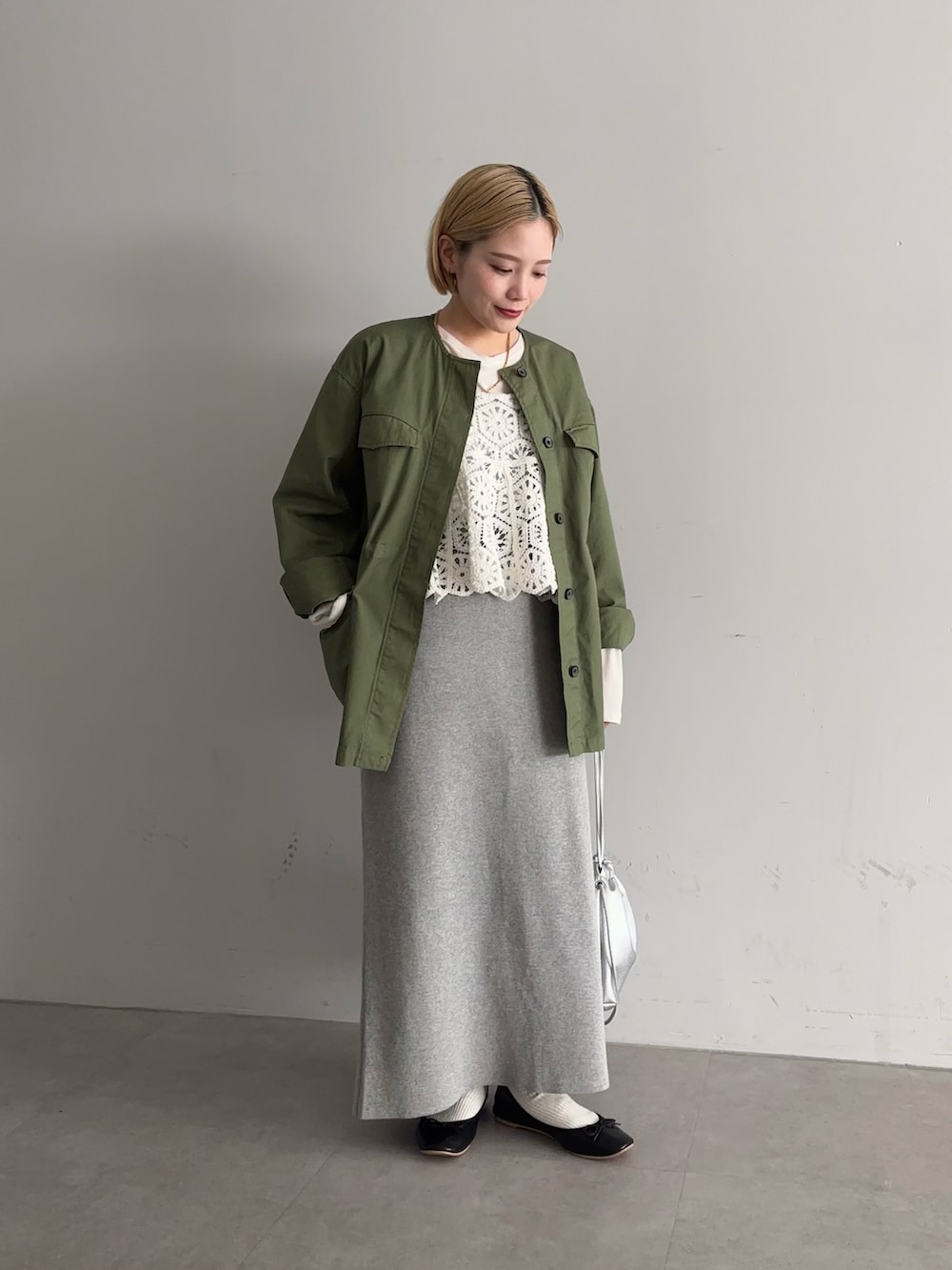 グレー系のスカート、ブラック系のバレエシューズ、シルバー系のショルダーバッグを着用したレディースの冬コーディネートの3枚目の写真