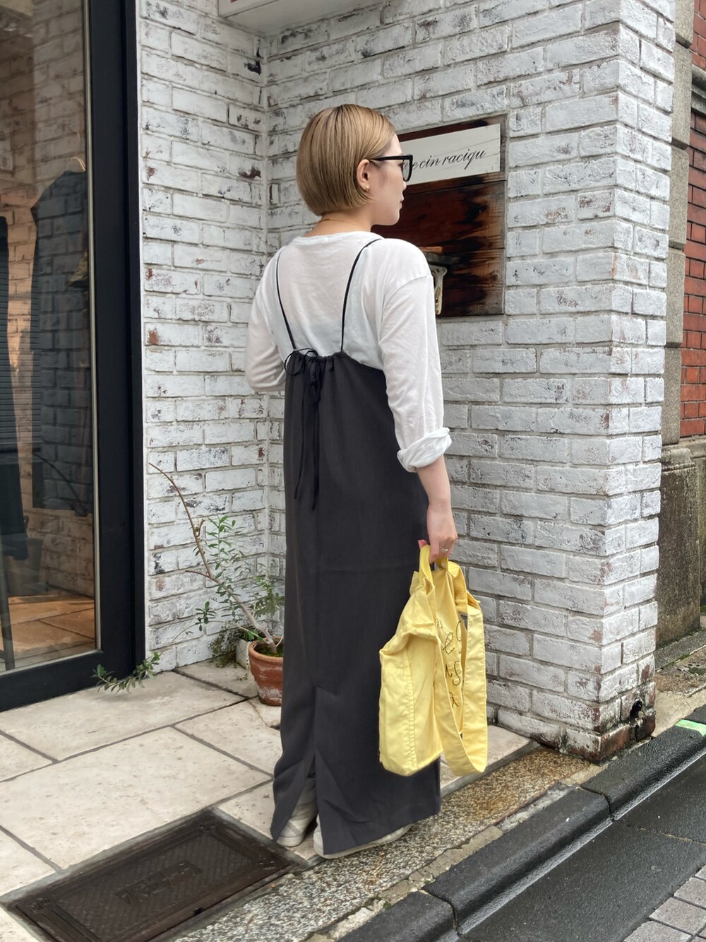 ベージュ系のスニーカー、イエロー系のトートバッグ、グレー系のワンピースを着用したレディースの秋コーディネートの3枚目の写真