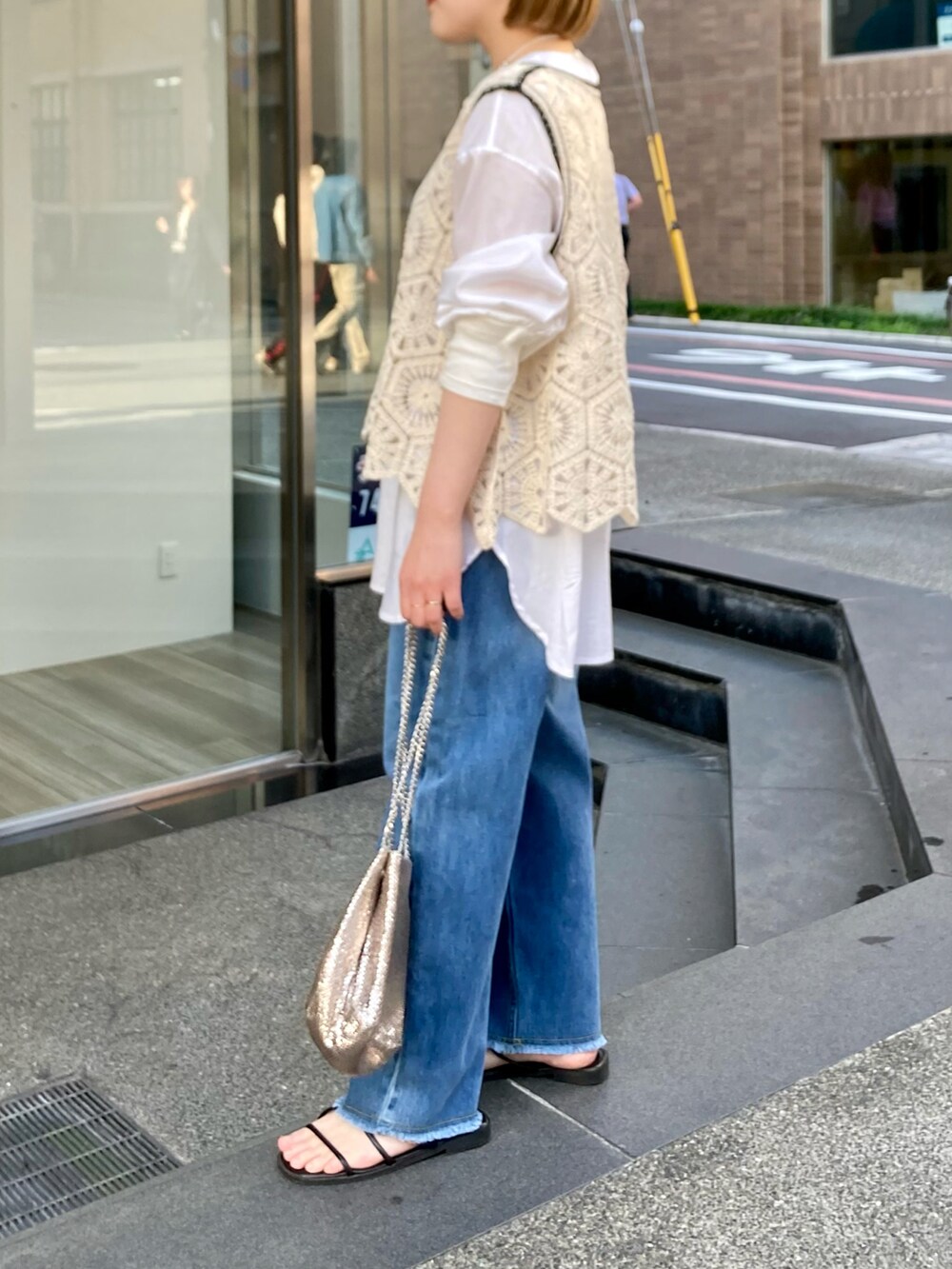 ゴールド系のショルダーバッグ、ブルー系のデニムパンツ、その他のトップスを着用したレディースの春コーディネートの3枚目の写真