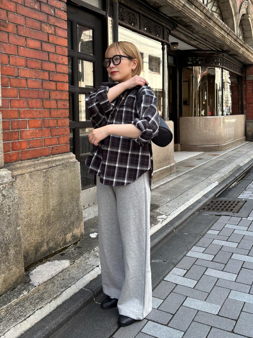 ブラック系のハンドバッグ、グレー系のスウェットパンツ、ブラック系のシャツ/ブラウスを着用したレディースの秋コーディネートの3枚目の写真