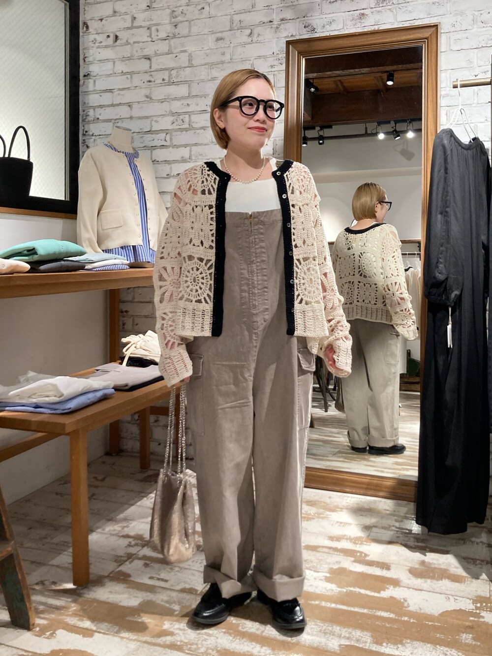 ブラック系のローファー、ゴールド系のショルダーバッグ、ベージュ系のサロペット/オーバーオールを着用したレディースの春コーディネートの2枚目の写真