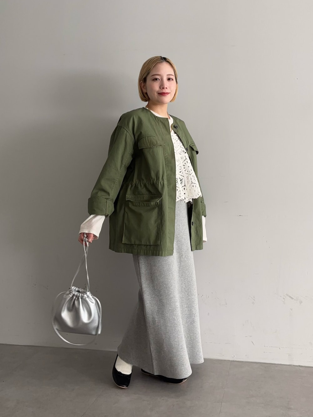 グレー系のスカート、ブラック系のバレエシューズ、シルバー系のショルダーバッグを着用したレディースの冬コーディネートの2枚目の写真