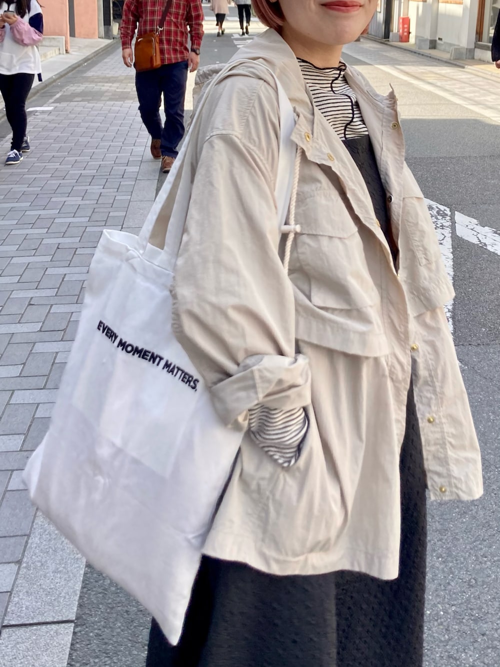 ブラック系のワンピース/ドレス、ブラック系のTシャツ/カットソー、ベージュ系のマウンテンパーカーを着用したレディースの春コーディネートの4枚目の写真