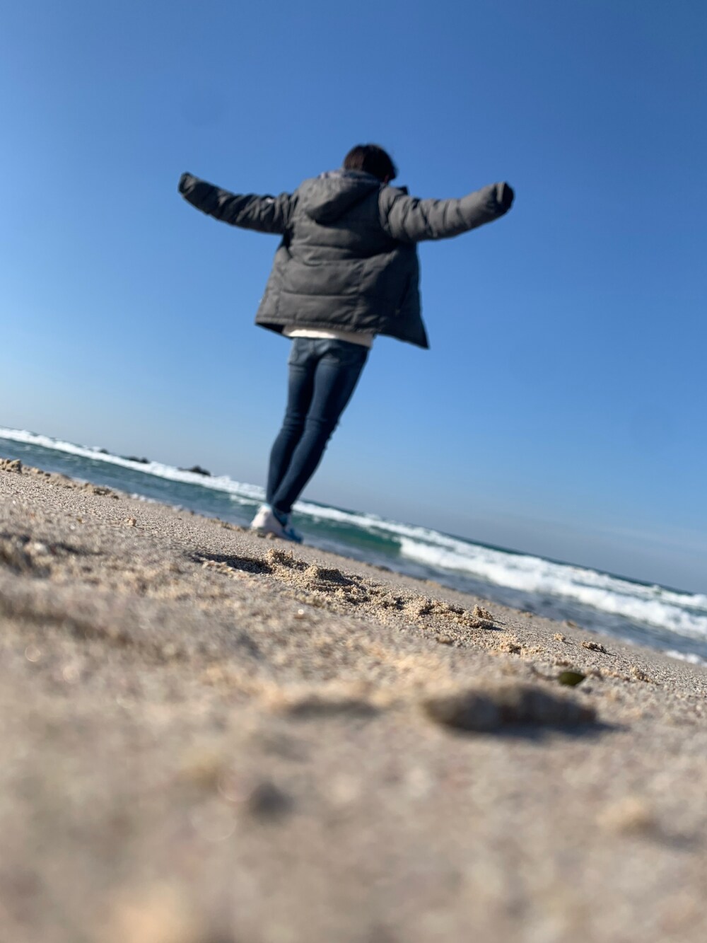 グレー系のジャケット/アウター、ブルー系のデニムパンツ、ブルー系のスニーカーを着用したメンズの冬コーディネートの2枚目の写真