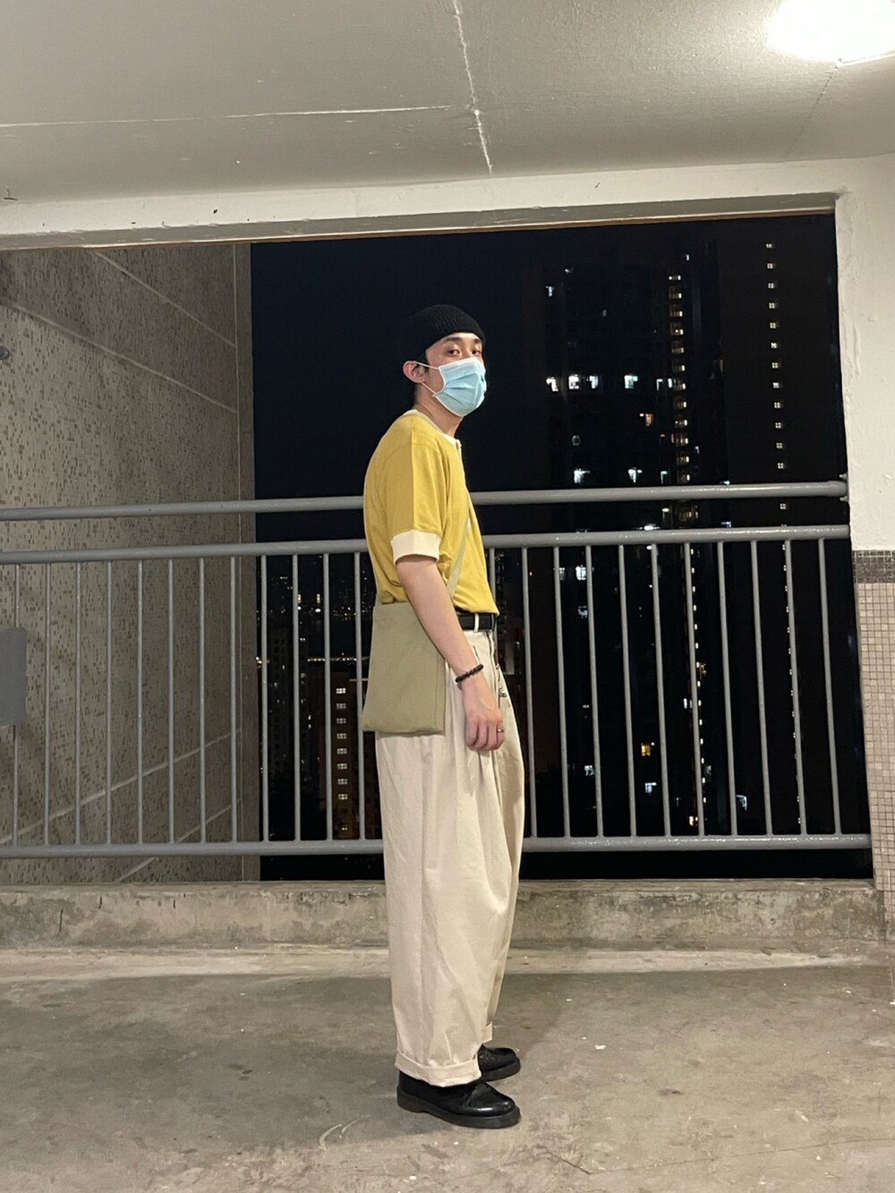 イエロー系のトップス、ベージュ系のパンツ、ブラック系のシューズを着用したメンズの秋コーディネートの2枚目の写真