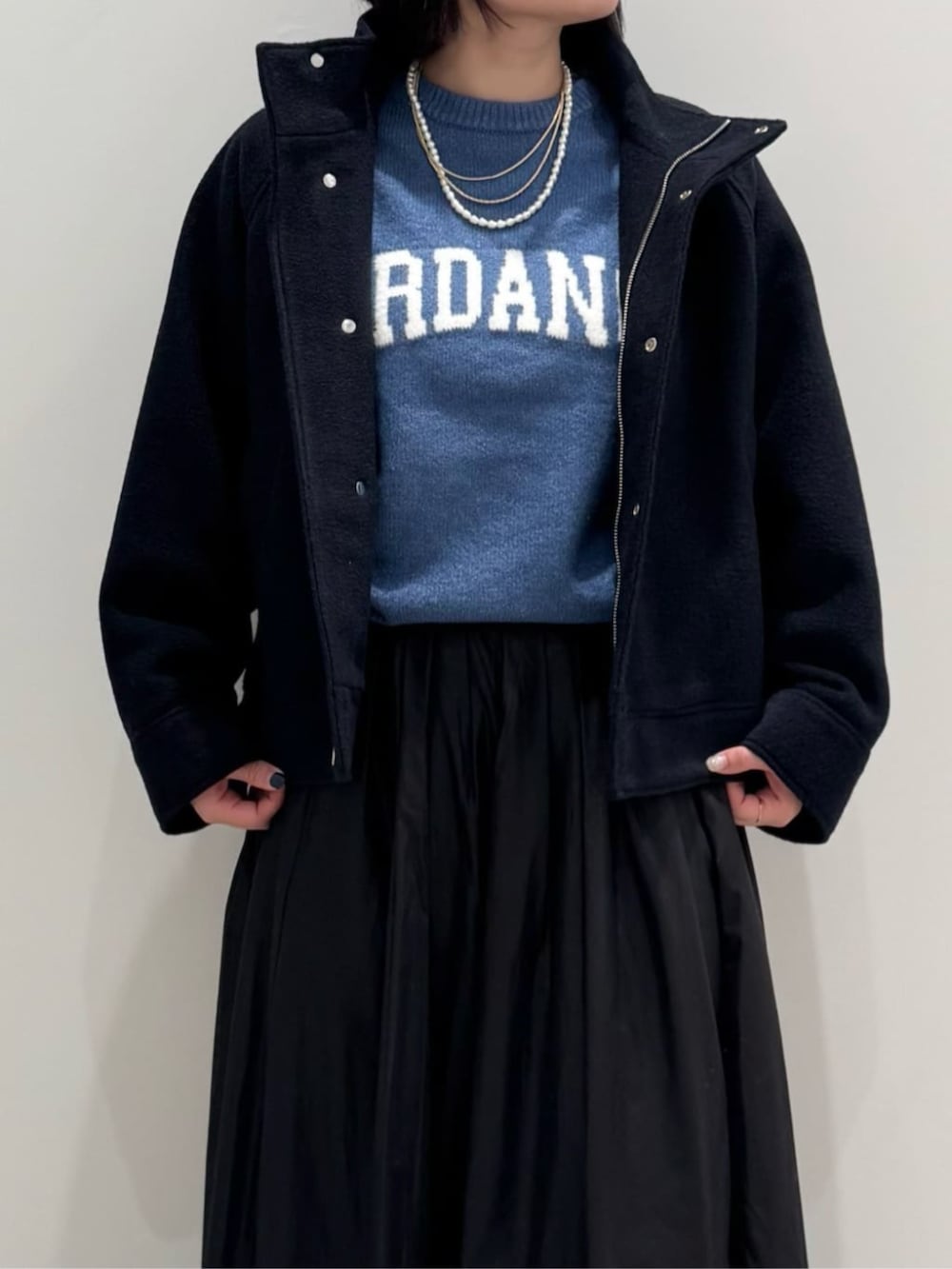 ブラック系のスカート、ブルー系のブルゾン、ブルー系のニット/セーターを着用したレディースの冬コーディネートの2枚目の写真