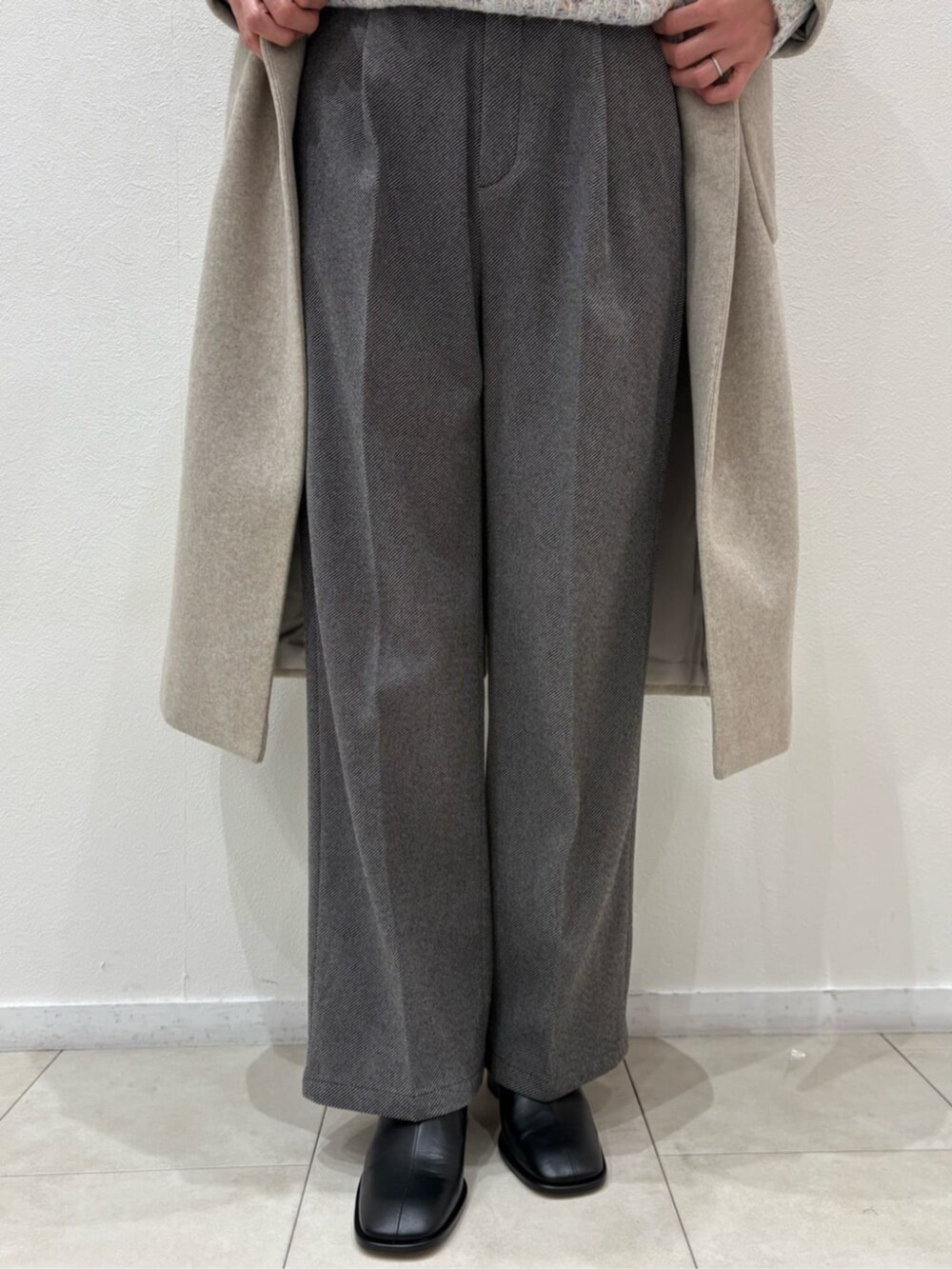 ブラック系のボストンバッグ、ベージュ系のチェスターコート、ホワイト系のニット/セーターを着用したレディースの冬コーディネートの4枚目の写真