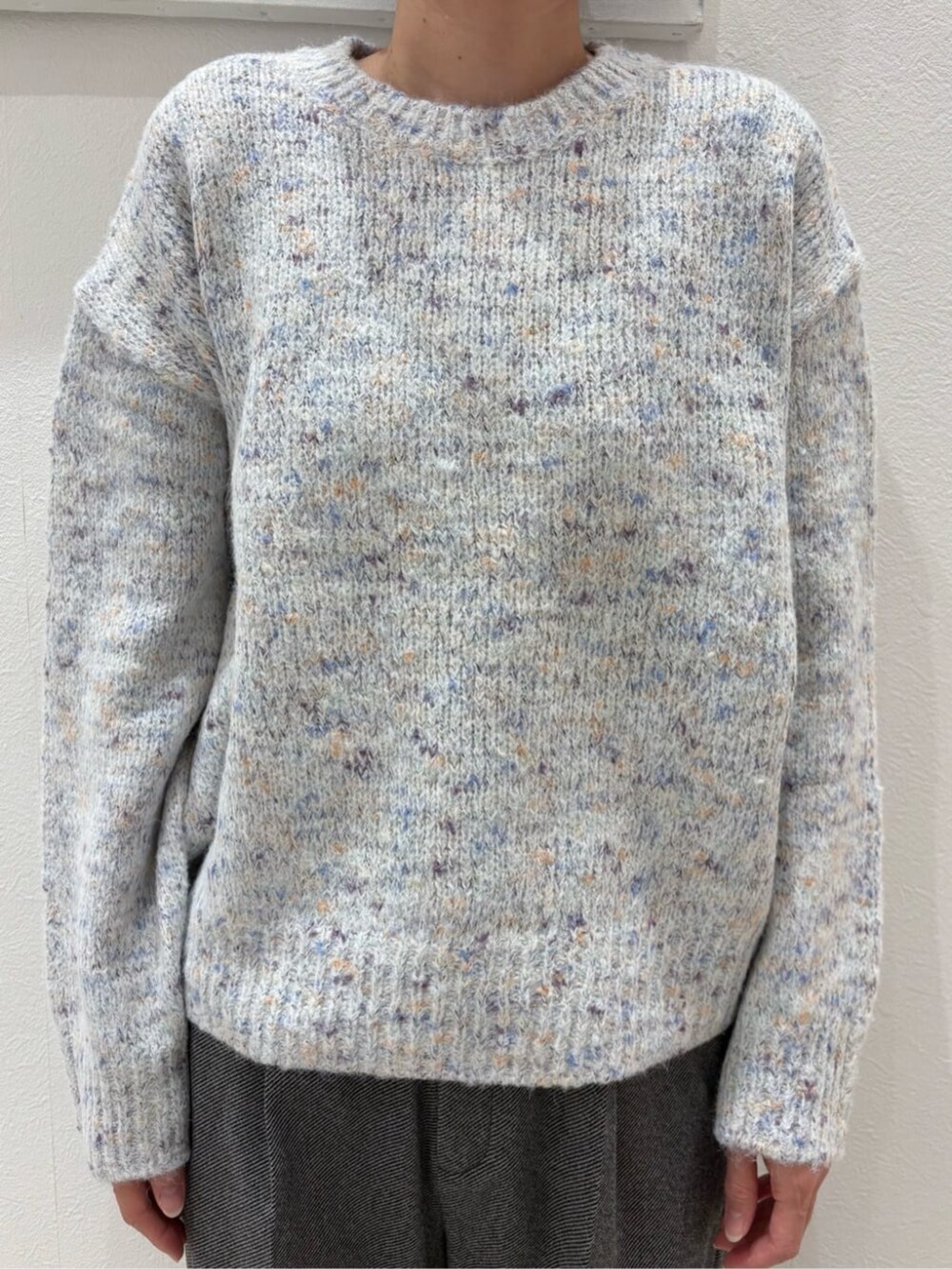 ブラック系のボストンバッグ、ベージュ系のチェスターコート、ホワイト系のニット/セーターを着用したレディースの冬コーディネートの3枚目の写真