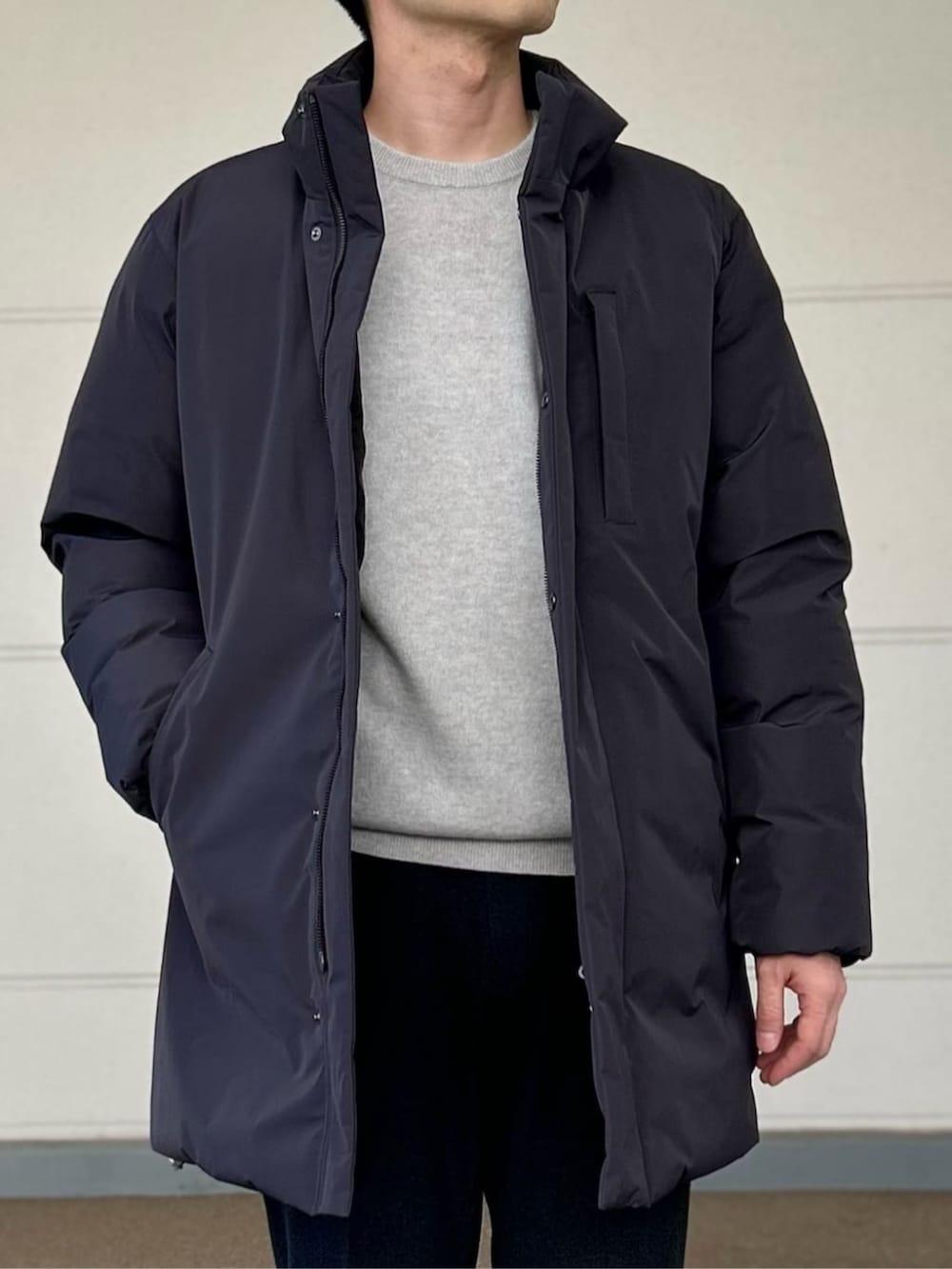 グレー系のその他アウター、グレー系のニット/セーター、グレー系のスラックスを着用したメンズの冬コーディネートの2枚目の写真