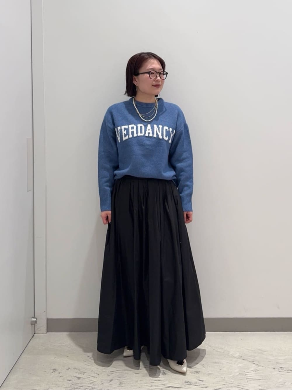 ブラック系のスカート、ブルー系のブルゾン、ブルー系のニット/セーターを着用したレディースの冬コーディネートの3枚目の写真