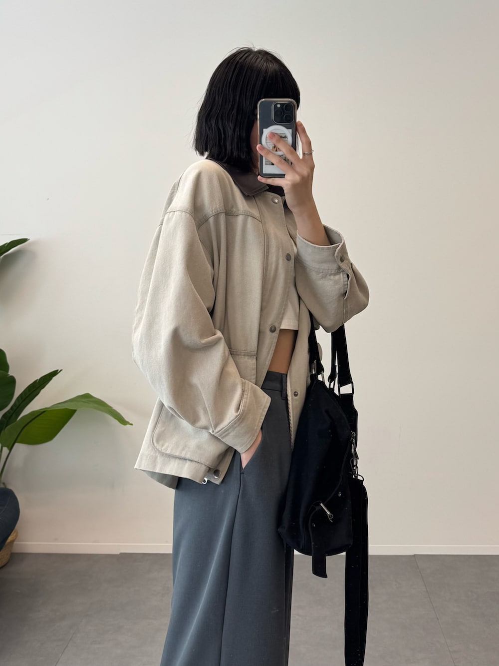 ベージュ系のデニムジャケット、グレー系のスラックス、ブラック系のボストンバッグを着用したレディースの冬コーディネートの4枚目の写真