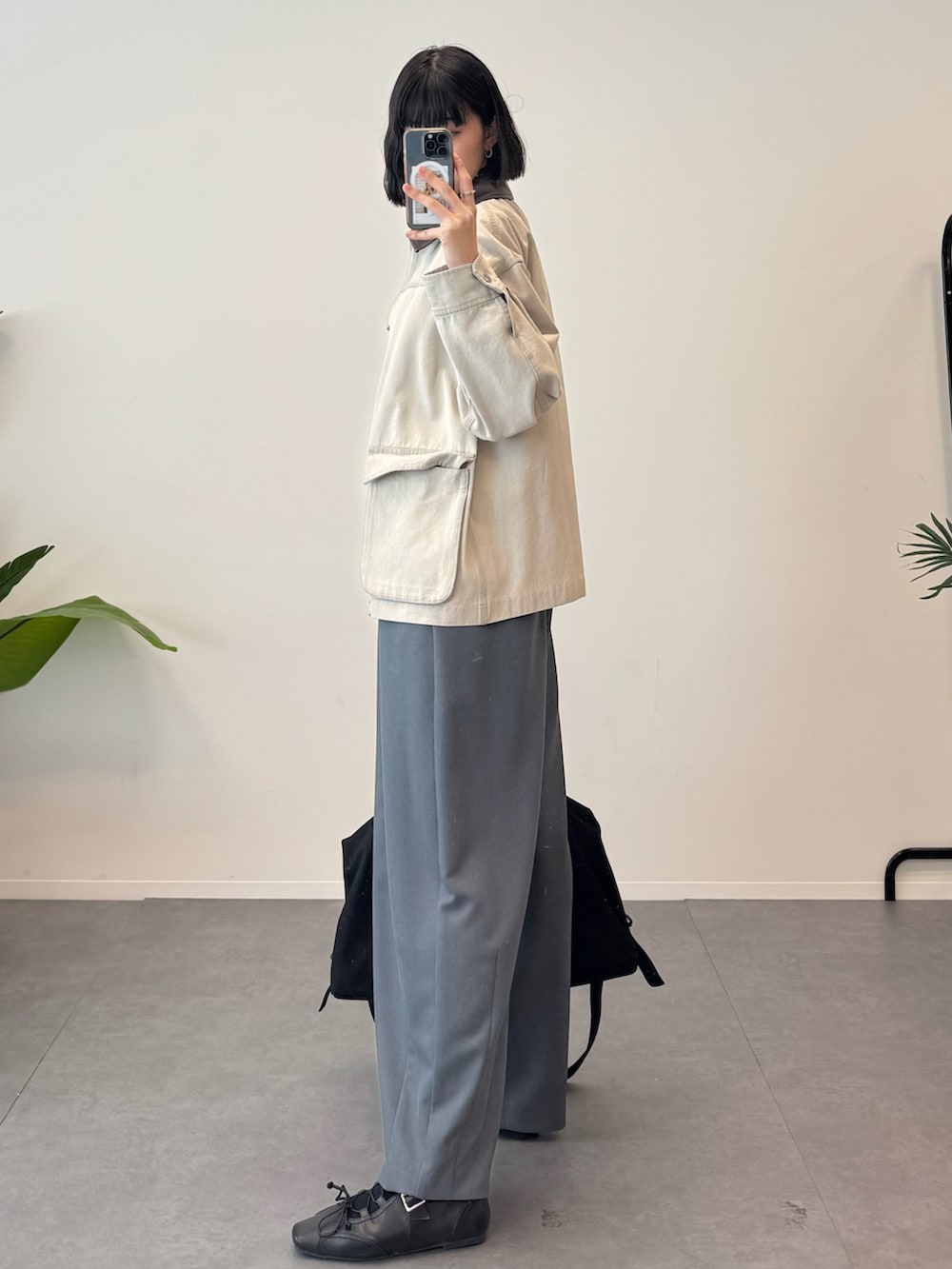 ベージュ系のデニムジャケット、グレー系のスラックス、ブラック系のボストンバッグを着用したレディースの冬コーディネートの2枚目の写真