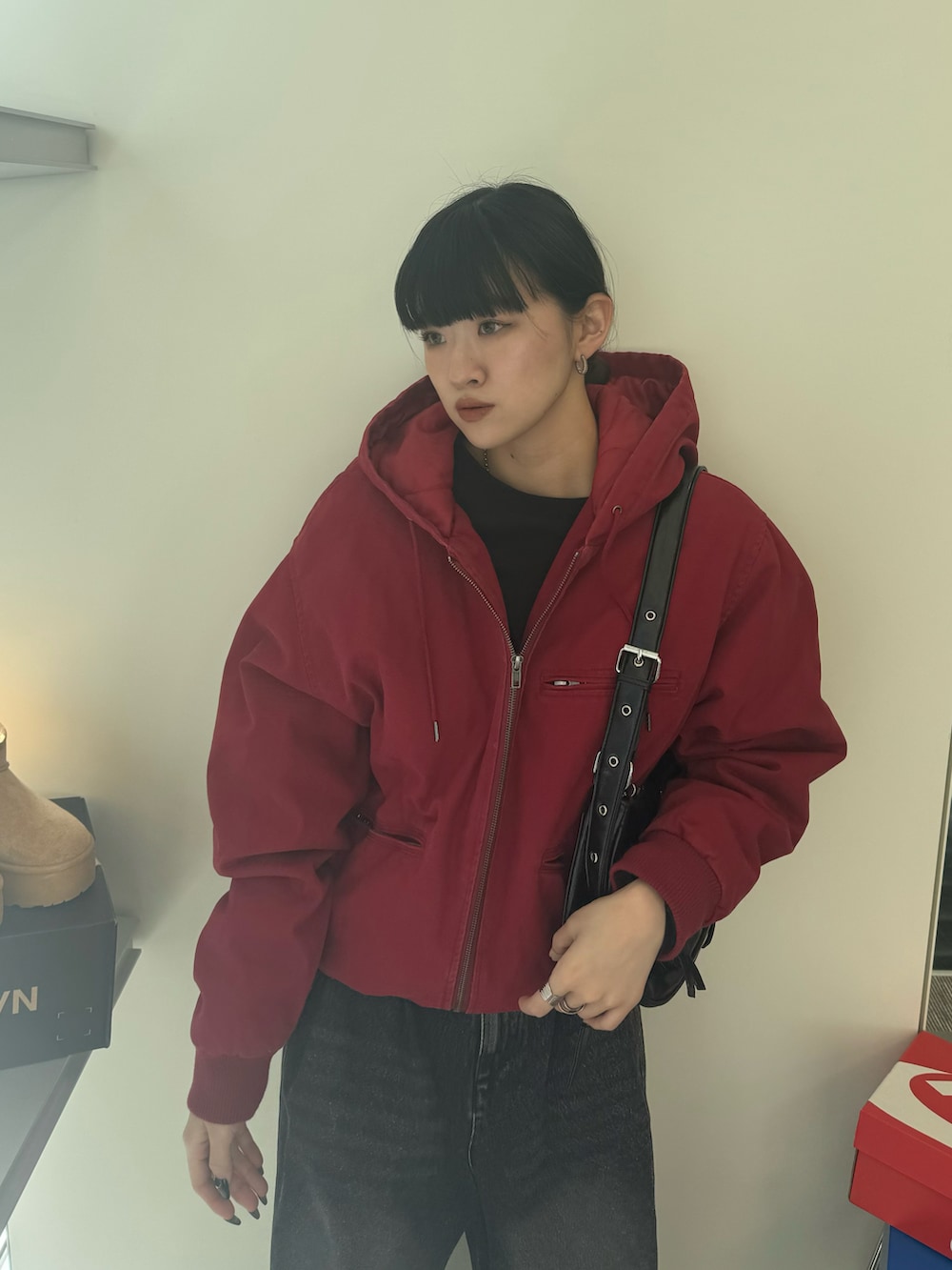 ブラック系のデニムパンツ、ブラウン系のブーツ、ブラック系のショルダーバッグを着用したレディースの秋コーディネートの4枚目の写真