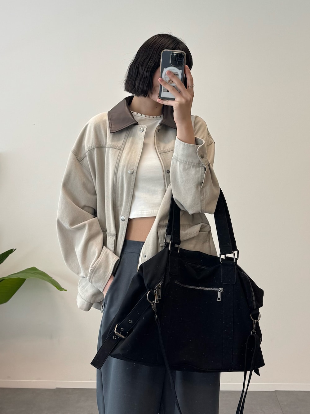 ベージュ系のデニムジャケット、グレー系のスラックス、ブラック系のボストンバッグを着用したレディースの冬コーディネートの3枚目の写真