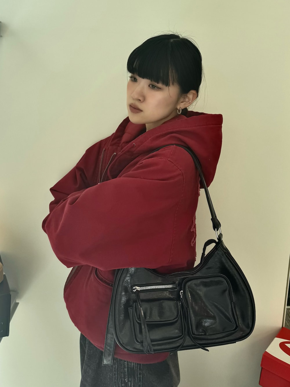 ブラック系のデニムパンツ、ブラウン系のブーツ、ブラック系のショルダーバッグを着用したレディースの秋コーディネートの5枚目の写真