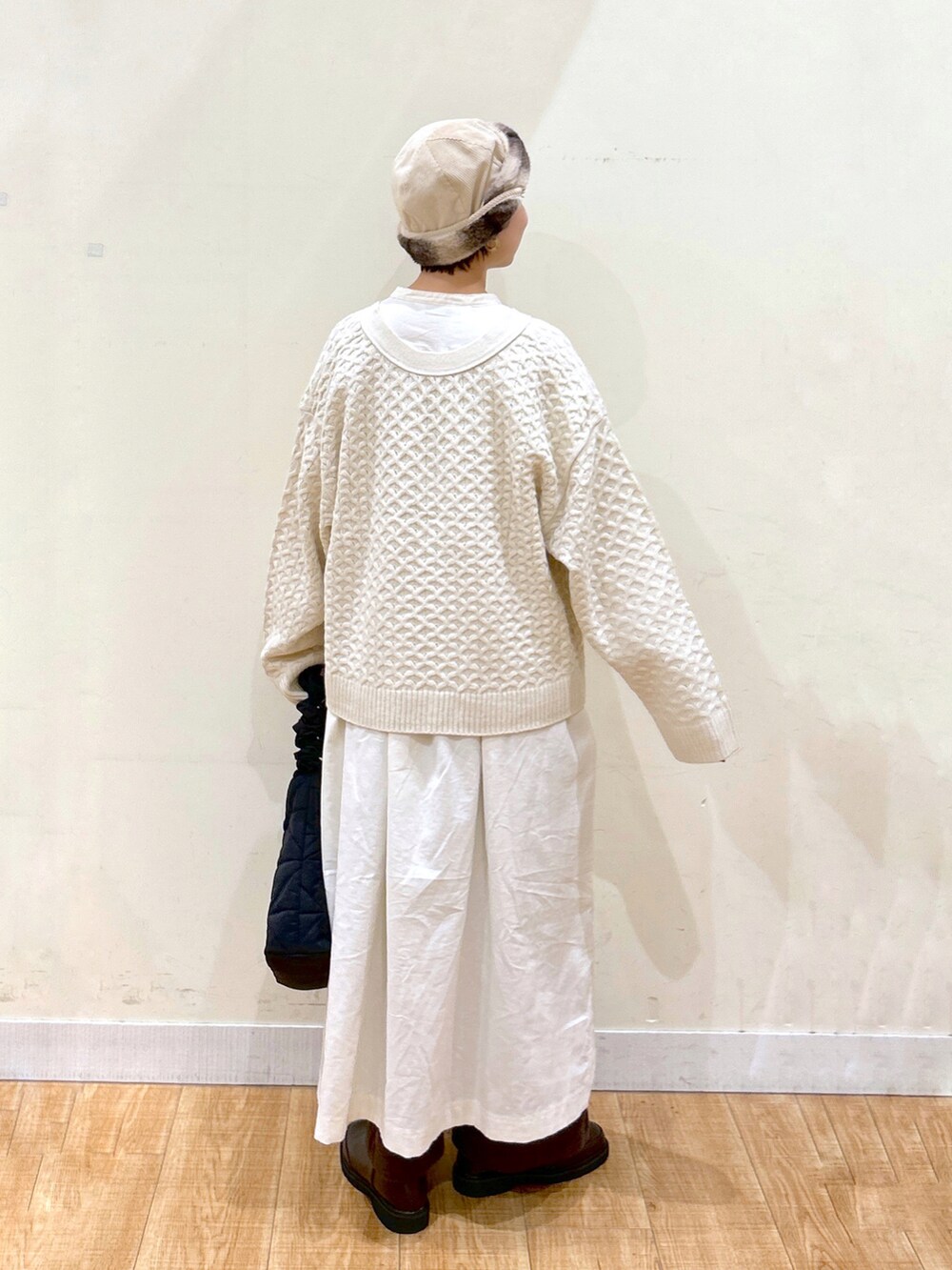 ホワイト系のカーディガン/ボレロ、ホワイト系のワンピース/ドレス、ブラック系のトートバッグを着用したレディースの秋コーディネートの4枚目の写真