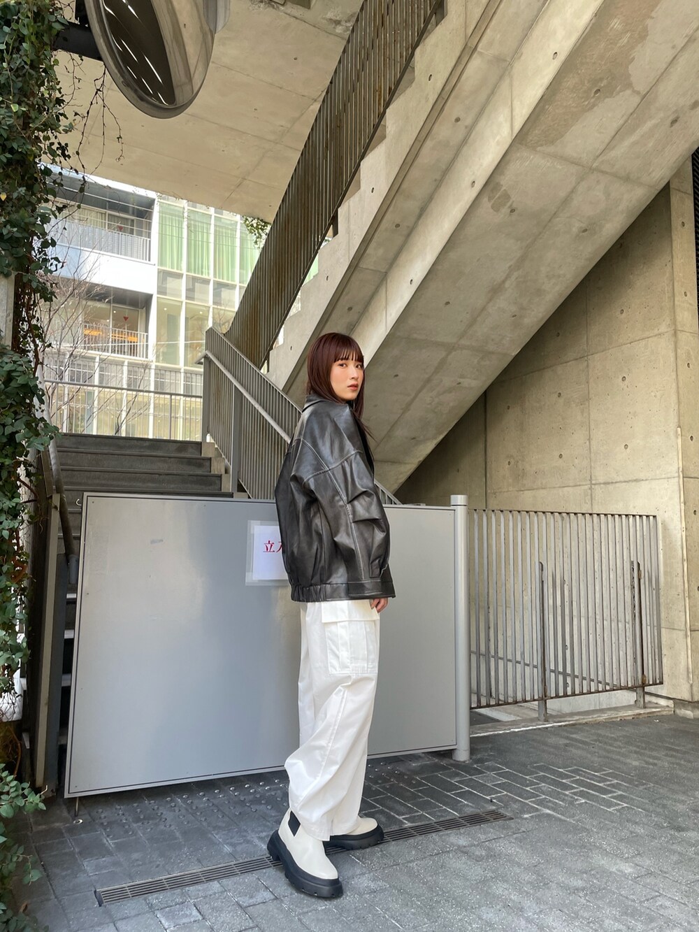 グレー系のブルゾン、ブルー系のニット/セーター、ホワイト系のカーゴパンツを着用したレディースの冬コーディネートの2枚目の写真